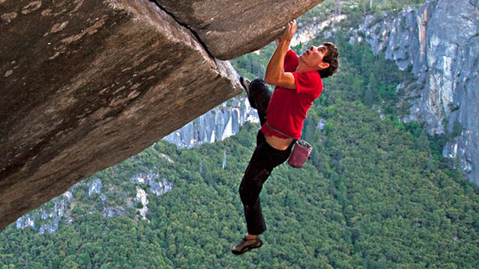 Alex Honnold climbing a rock without a rope.